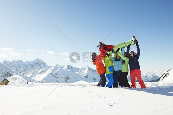 朋友们在雪地里举起年轻的女人库泰奥地利图片