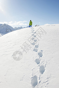 站在雪地里有脚印的人图片