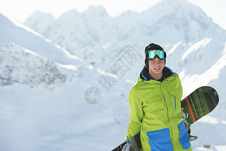年轻人拿着滑雪板图片