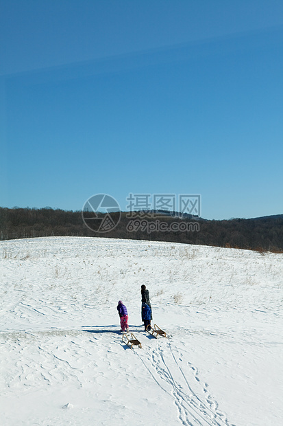 母亲和两个孩子在雪地图片