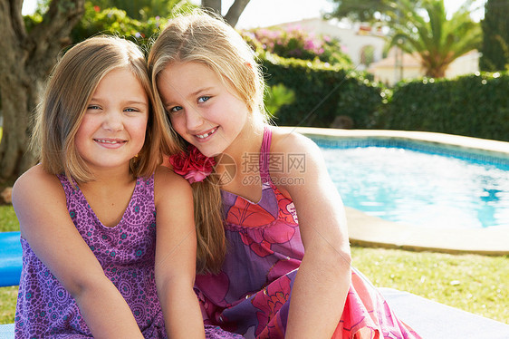 两个女孩在泳池边拥抱图片