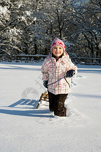 在雪地里拉雪橇的小女孩图片