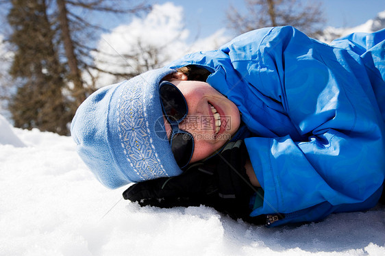 穿着蓝色衣服的女孩躺在雪地里图片