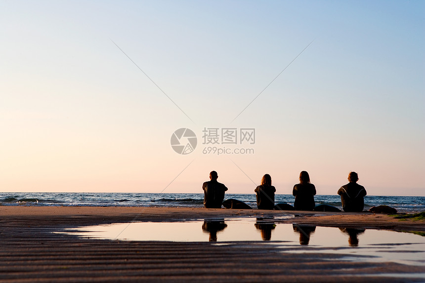 四个人坐在海滩上图片