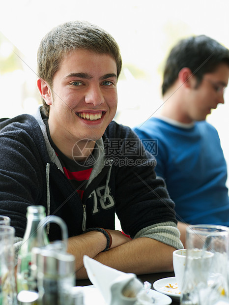 年轻男性坐在咖啡馆的照片图片