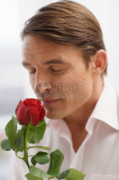 英俊的男人闻玫瑰的香味图片