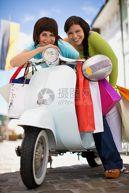 坐在摩托车上的两个购物的女人图片