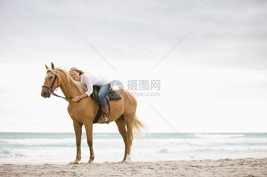 在海滩上骑马的女人图片