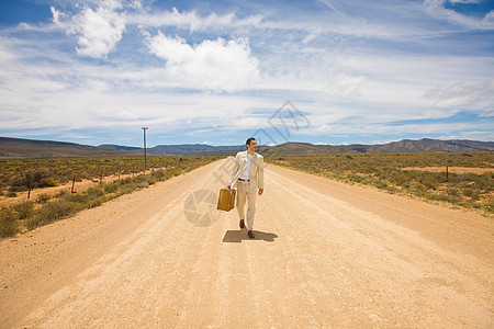 一个男人走在沙漠的路上图片