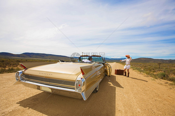 在沙漠路上搭车的女人图片