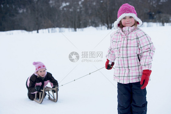 玩雪橇的年轻女孩图片