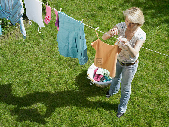 女人把衣服挂在晾衣绳上图片