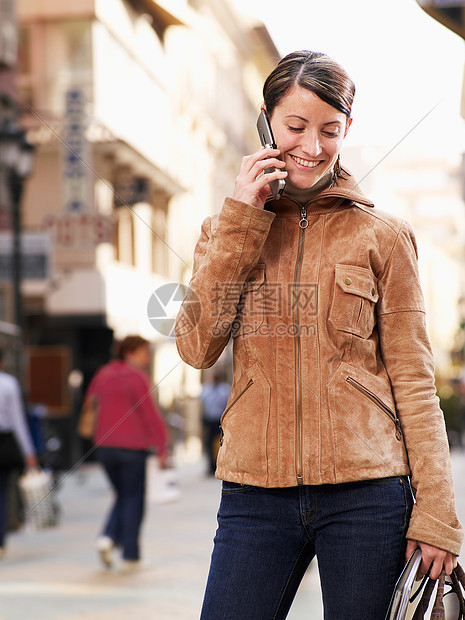 站在街上打电话的年轻女子图片
