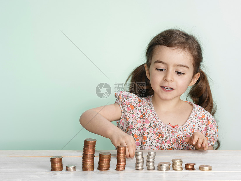 女孩在台面上堆硬币图片