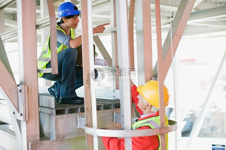 女建筑师和建筑工人交谈图片