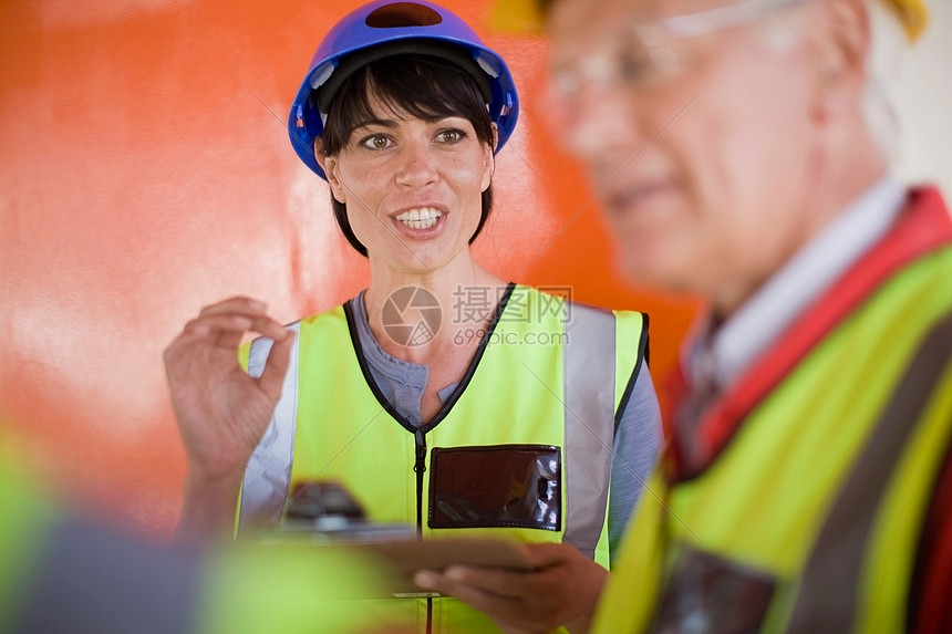 女建筑师与建筑工人交谈图片