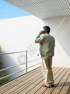站在阳台上男人站在阳台上打电话的男人背景