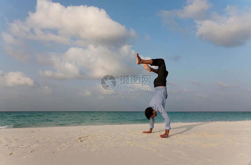 商人在海滩上倒立图片