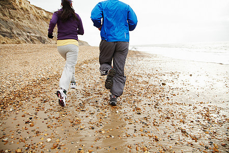 在海边奔跑的年轻夫妇图片