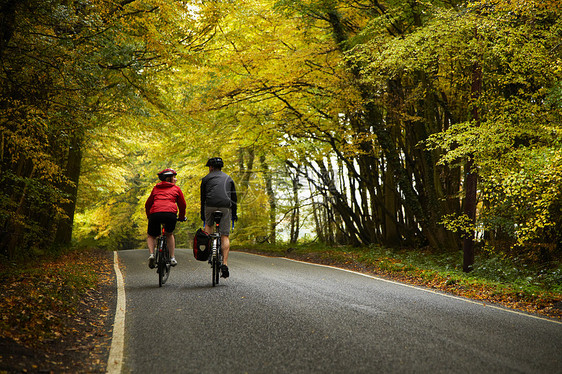 一对夫妇沿着乡村公路骑车图片