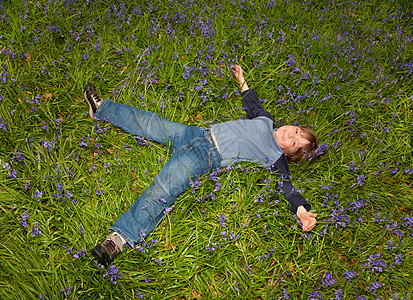 男孩躺在风铃草田里图片