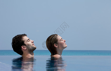 游泳池里放松的情侣图片