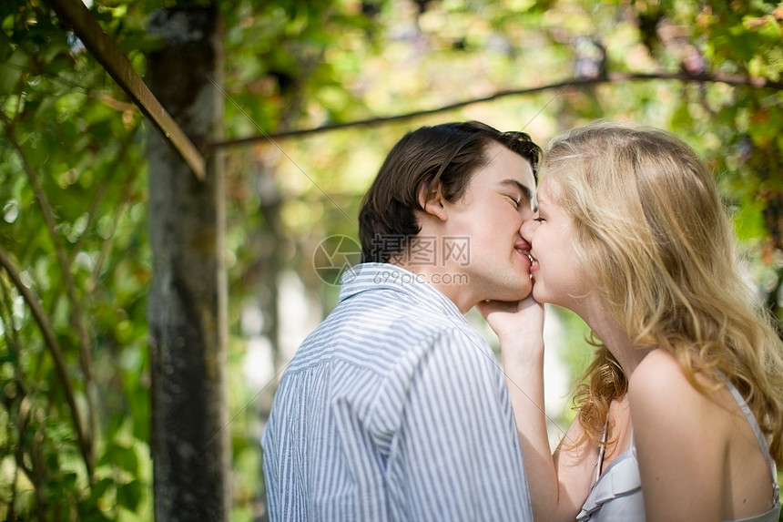 在花园里亲吻的夫妇图片