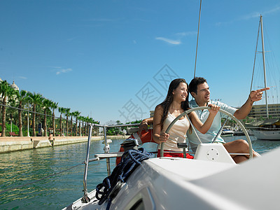 在码头上驾驶游艇的年轻夫妇图片