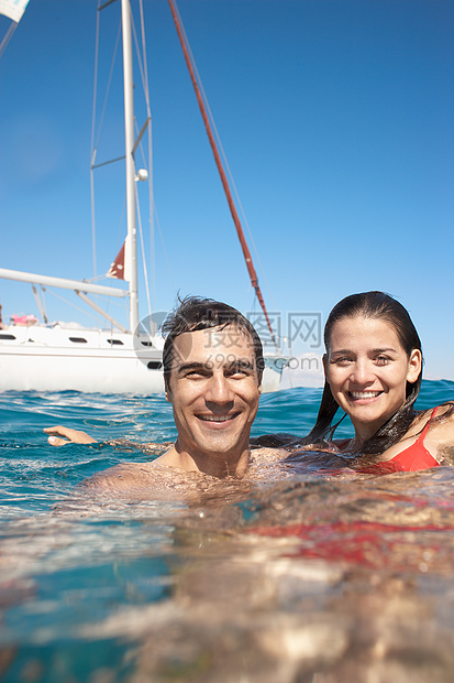 年轻夫妇乘游艇在海上游泳图片