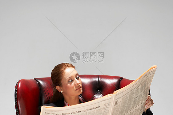 坐在舒适的皮椅上的女商人图片