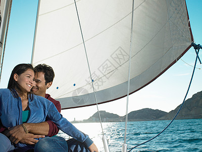 年轻夫妇在游艇上放松，微笑着图片