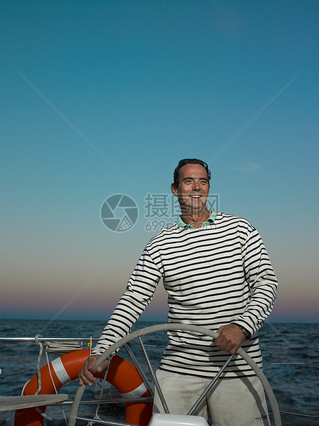 成熟的男子驾驶游艇微笑图片