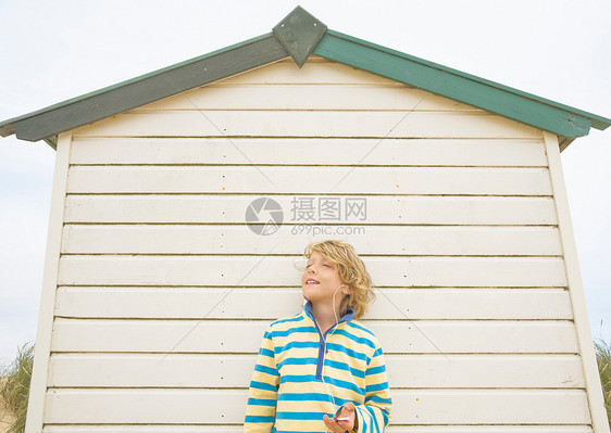 男孩靠在沙滩小屋上图片