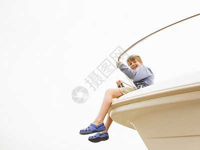 坐在游艇船头的男孩图片