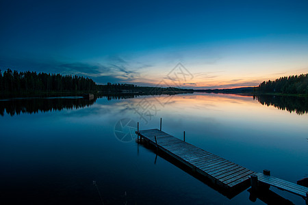 瑞典拉普兰斯凯尔夫特岛黎明时分的湖和木码头图片