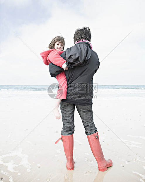 在海滩上抱孩子的女人图片