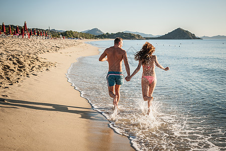 意大利撒丁岛卡斯蒂达斯，一对年轻夫妇在海上奔跑图片