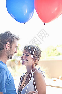 带着气球在户外微笑的情侣图片