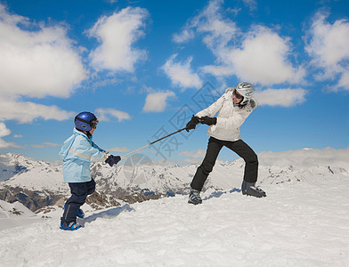 女人把男孩拉上雪山图片