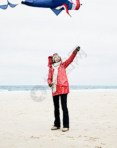 海滩上带风筝的女人图片