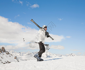 女人带着滑雪板在雪地里上山背景图片