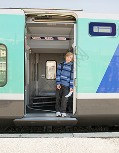 男孩拿着票站在火车上图片