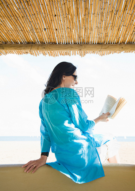 在海滩上看书的女人图片