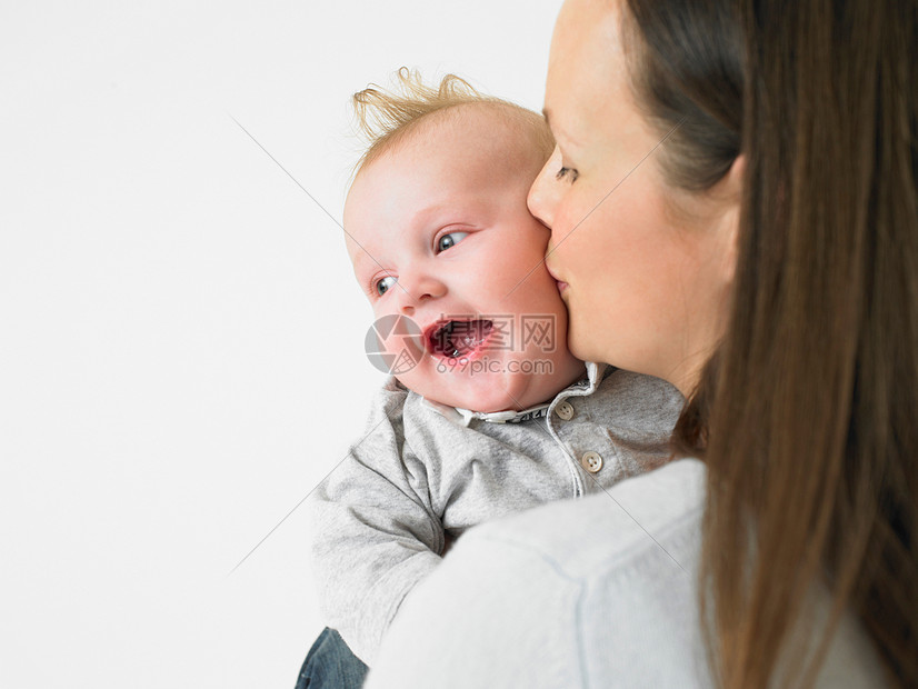 母亲亲吻婴儿的脸颊图片
