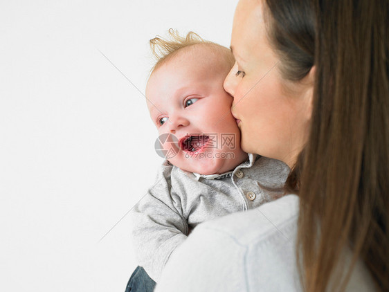 母亲亲吻婴儿的脸颊图片