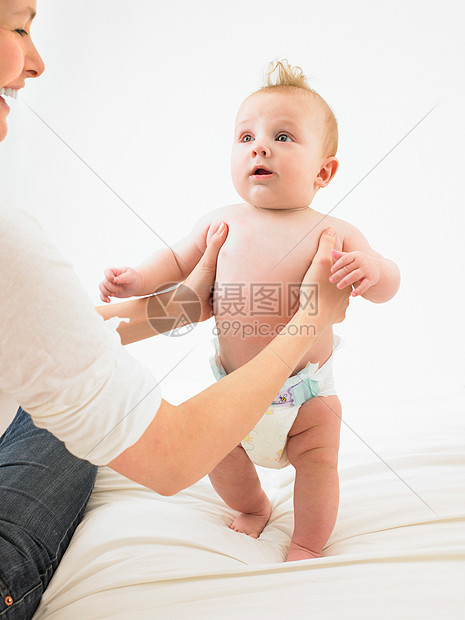 婴儿在妈妈的帮助下站立图片