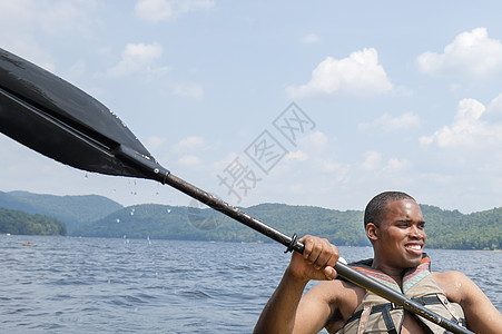 拿着船桨的年轻人背景图片