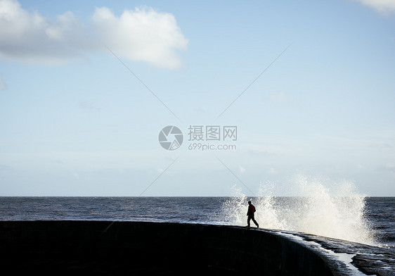 壁上躲避海浪的人图片