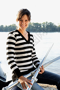 坐在木筏上拿着两个桨的女人图片