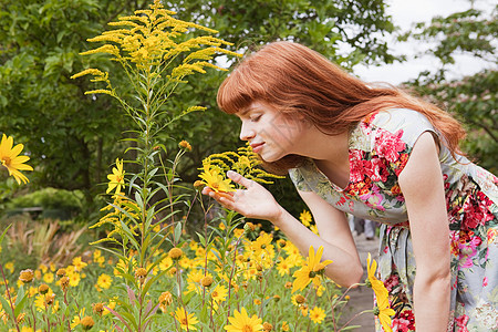 女人闻公园里的花图片